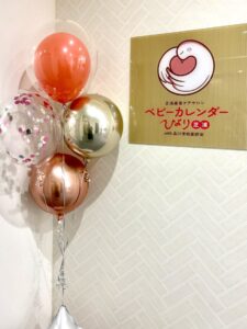 芝浦産後ケアサロン ベビーカレンダーひより芝浦の公式ロゴ。ハートの中に赤ちゃんを抱く手のアイコンと、柔らかいピンクのロゴ文字がデザインされている。